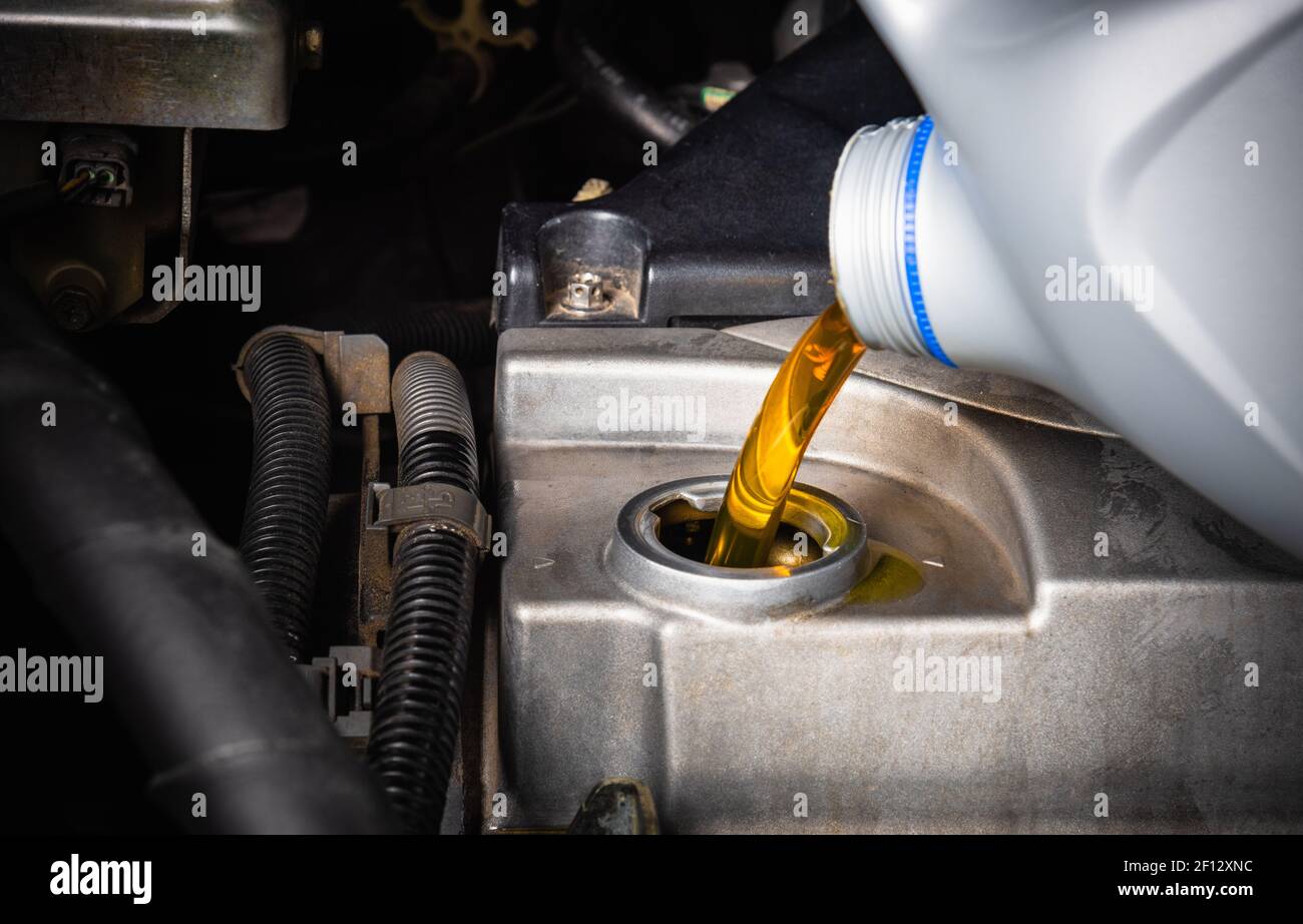 Mechanic in service to repair the car, refueling and pouring from