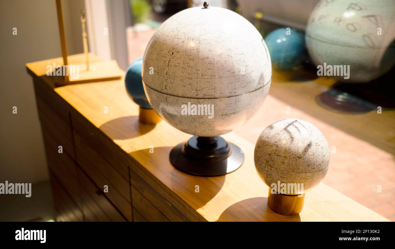 set of world globes on a wooden table with mirror Stock Photo