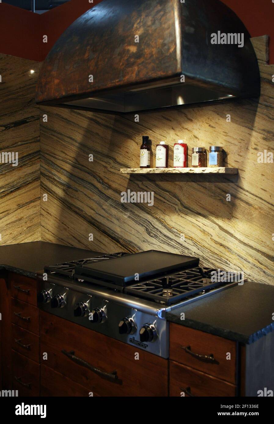 This kitchen display featuring a granite backsplash and a gas cooktop