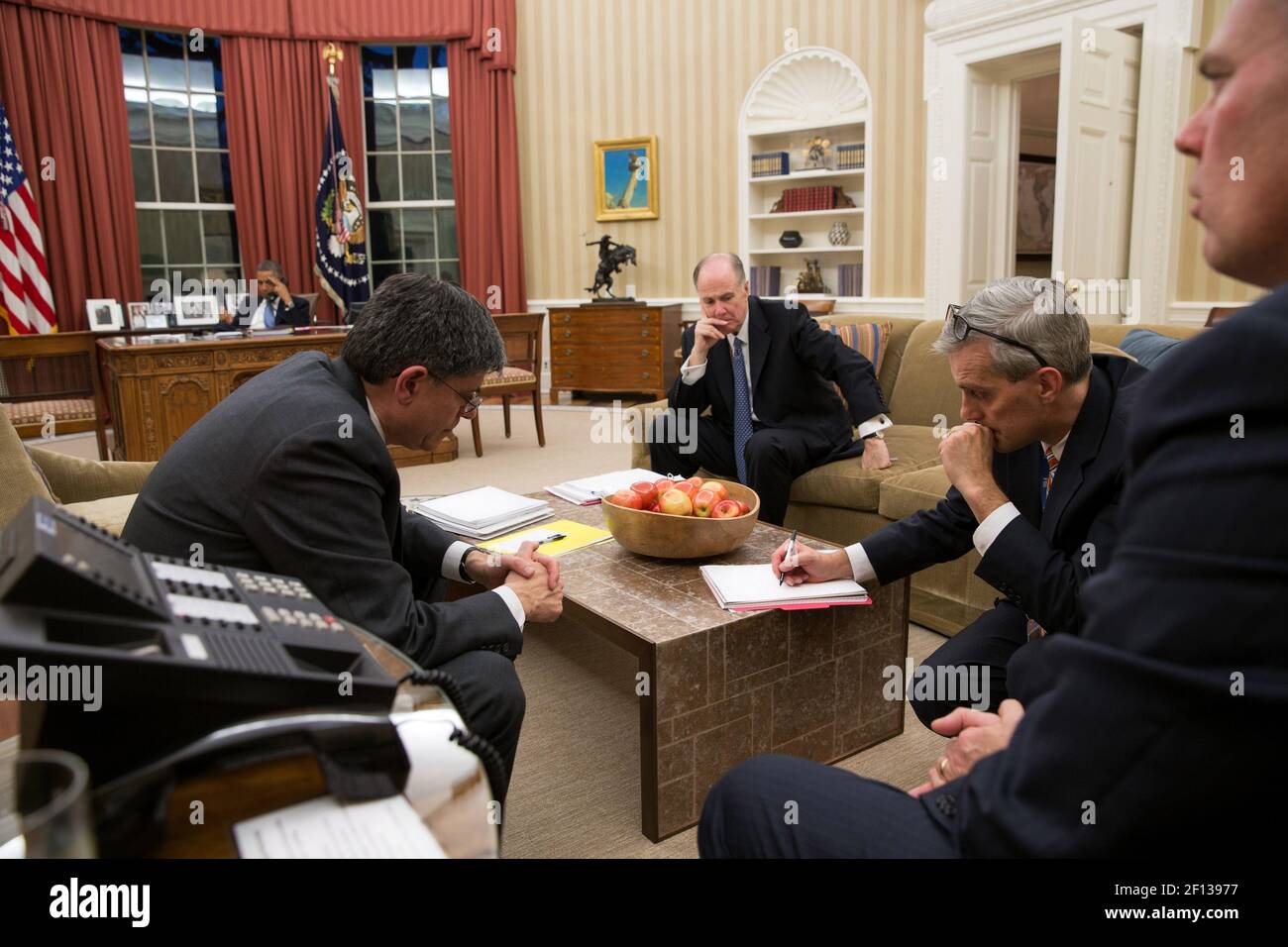 President Barack Obama talks on the phone with Egyptian President Mohammed Morsi in the Oval Office Nov. 14 2012. Jack Lew, Tom Donilon and Denis McDonough listen in the foreground. Stock Photo