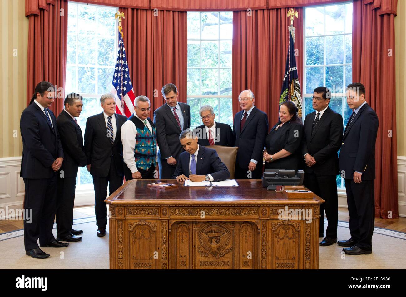 President Barack Obama signs H.R. 205 HEARTH Act of 2012 in the Oval Office July 30 2012. Standing behind the President from left are: Bryan Newland Senior Policy Advisor at the Department of the Interior; Governor Randall Vicente Pueblo of Acoma in New Mexico; David Hayes Deputy Secretary of the Department of the Interior; Jefferson Keel President of the National Congress of American Indians; Rep. Martin Heinrich D-N.M.;  Sen. Daniel Akaka D-Hawaii; interior Secretary Ken Salazar; Cheryl Causley Chairperson of the National American Indian Housing Council; Governor Gregory Mendoza Gila River I Stock Photo