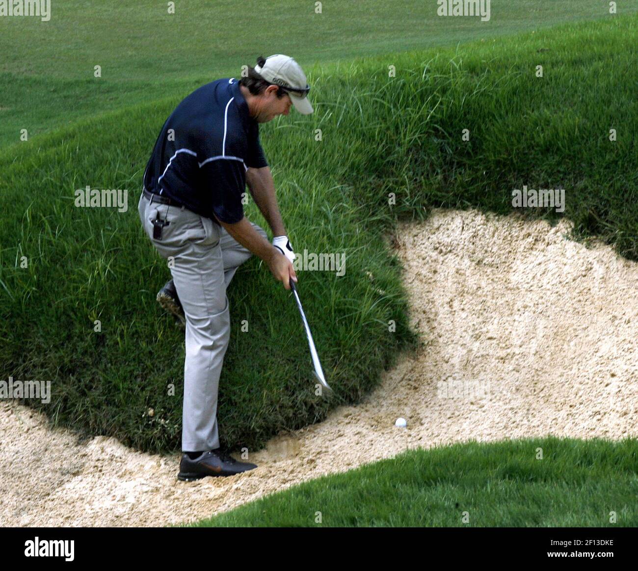 Paul Azinger attempts to hit out of a bunker during a challenge game