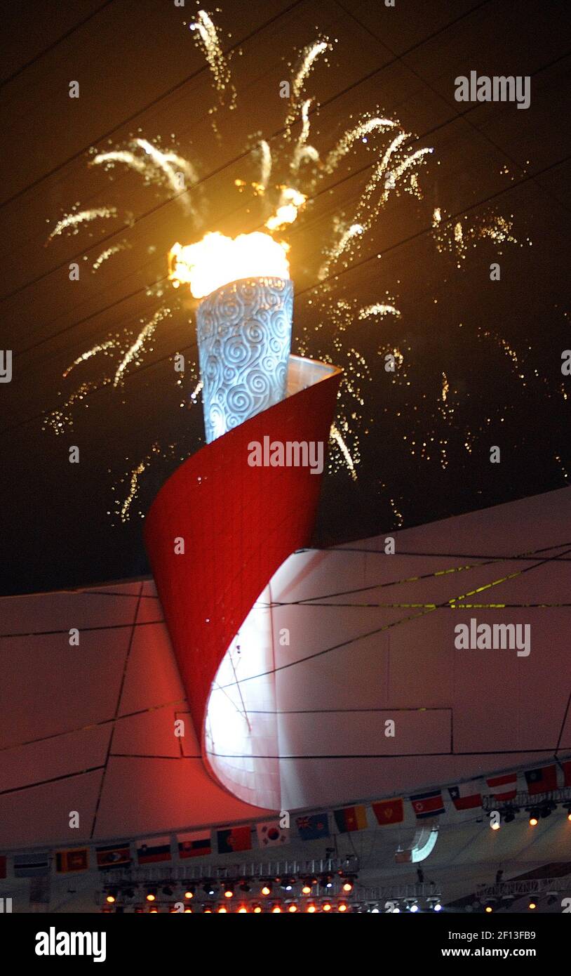 Fireworks explode as the Olympic flame burns in the cauldron on the ...