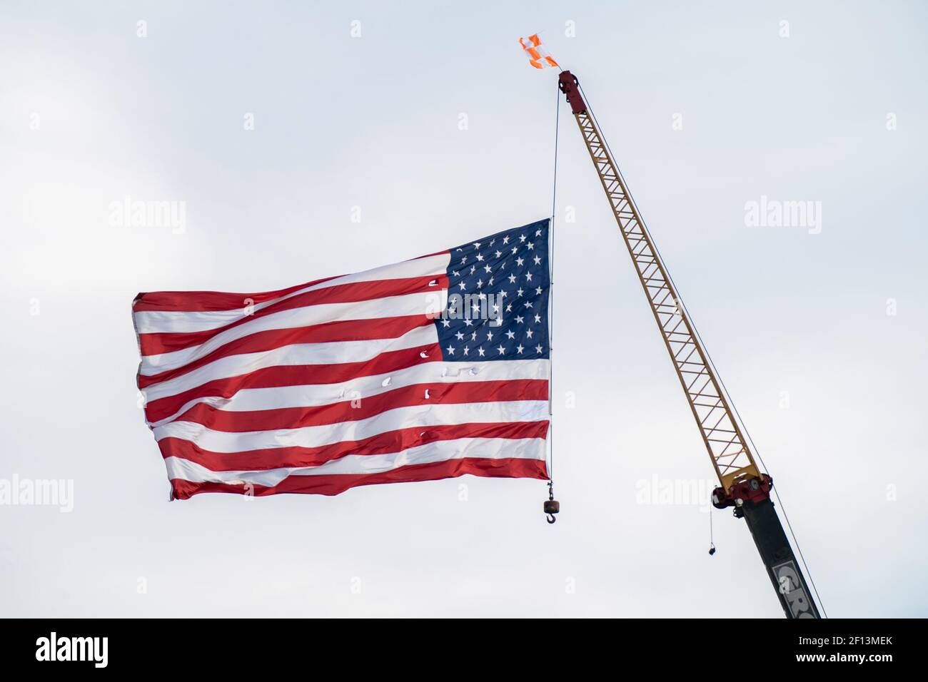 A large flag flies from a crane welcoming President Donald Trump on his arrival Sunday Sept. 22 2019 on the motorcade from Lima Ohio to Wapakoneta Ohio. Stock Photo