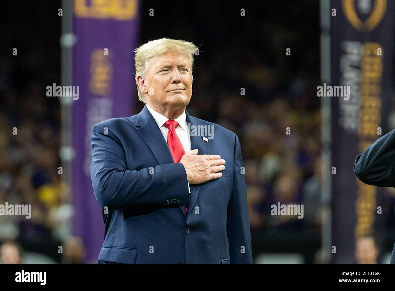 President Donald Trump participates in the National Anthem at the College Football Playoff National Championship Monday Jan. 13 2020 at the Mercedes-Benz Superdome in New Orleans. Stock Photo