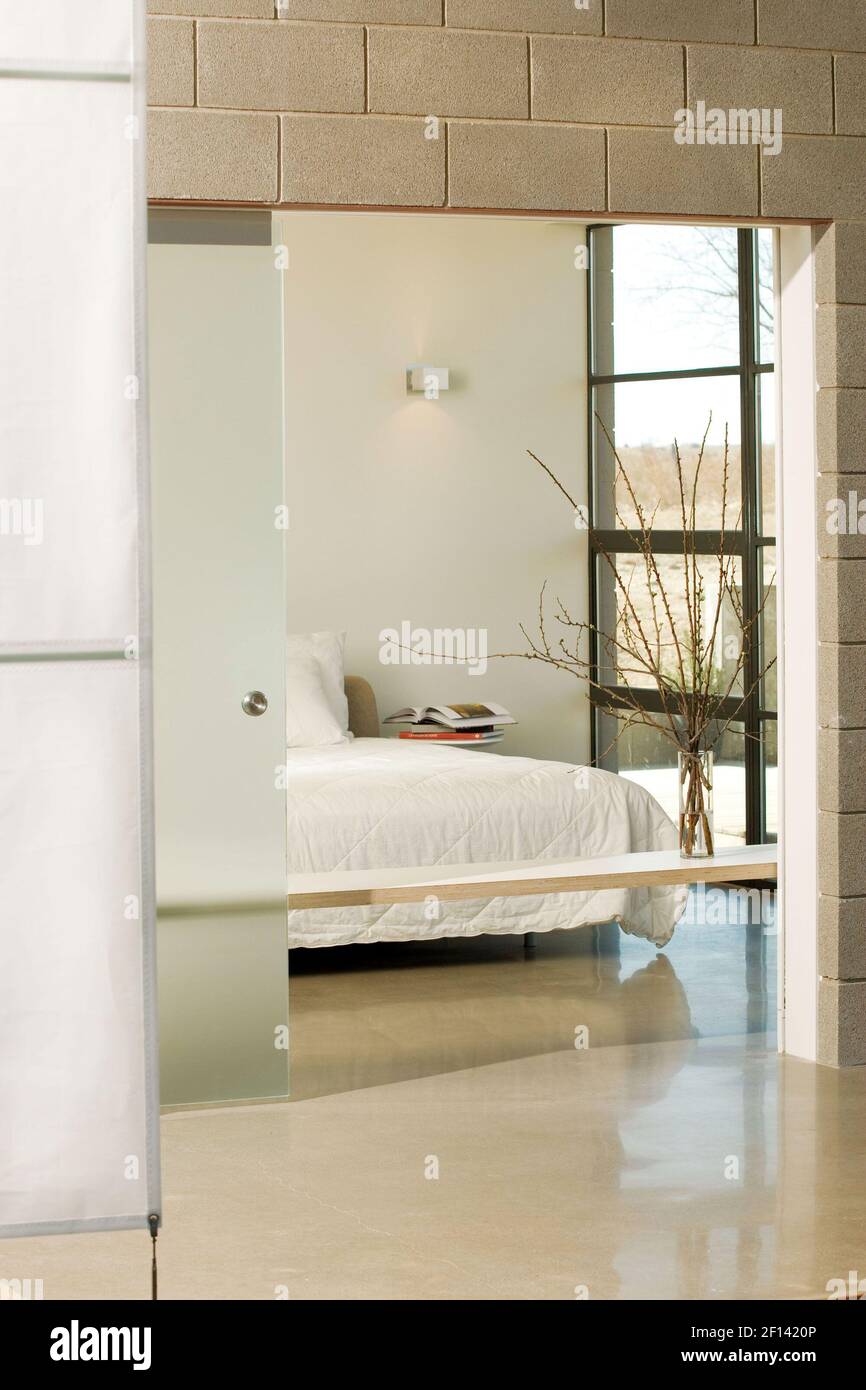 The master bedroom opens up to the living room, but an etched glass pocket  door offers privacy when needed. A laminate shelf helps create a division  of space while also providing an