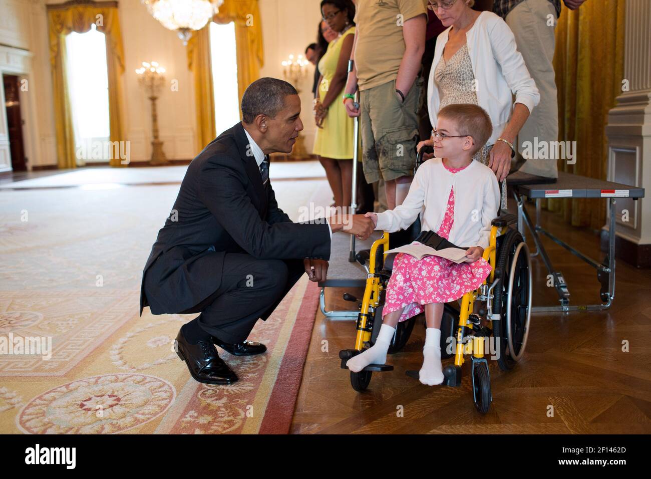 President Barack Obama greets Holli Benson during a visit with wounded warriors in the East Room of the White House, Aug. 23, 2012. Benson accompanied her brother, SSG Michael Benson, during a tour of the White House Stock Photo
