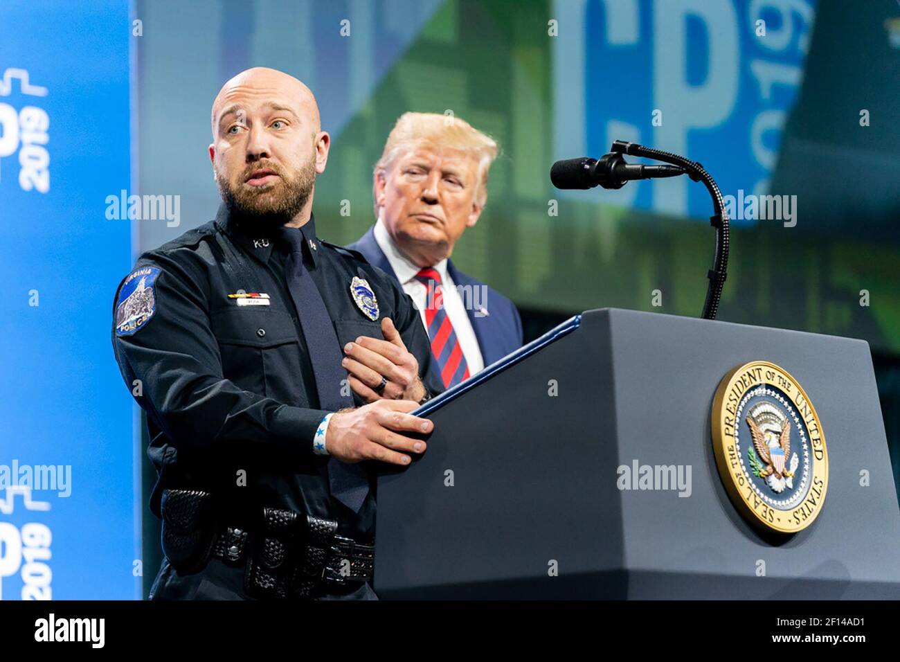 President Donald Trump listens as K9 Officer Nick Grivna of the Virginia Minnesota Police Department addresses the International Association of Chiefs of Police Annual Conference and Exposition at the McCormick Place Convention Center Monday Oct. 28 2019 in Chicago. Stock Photo