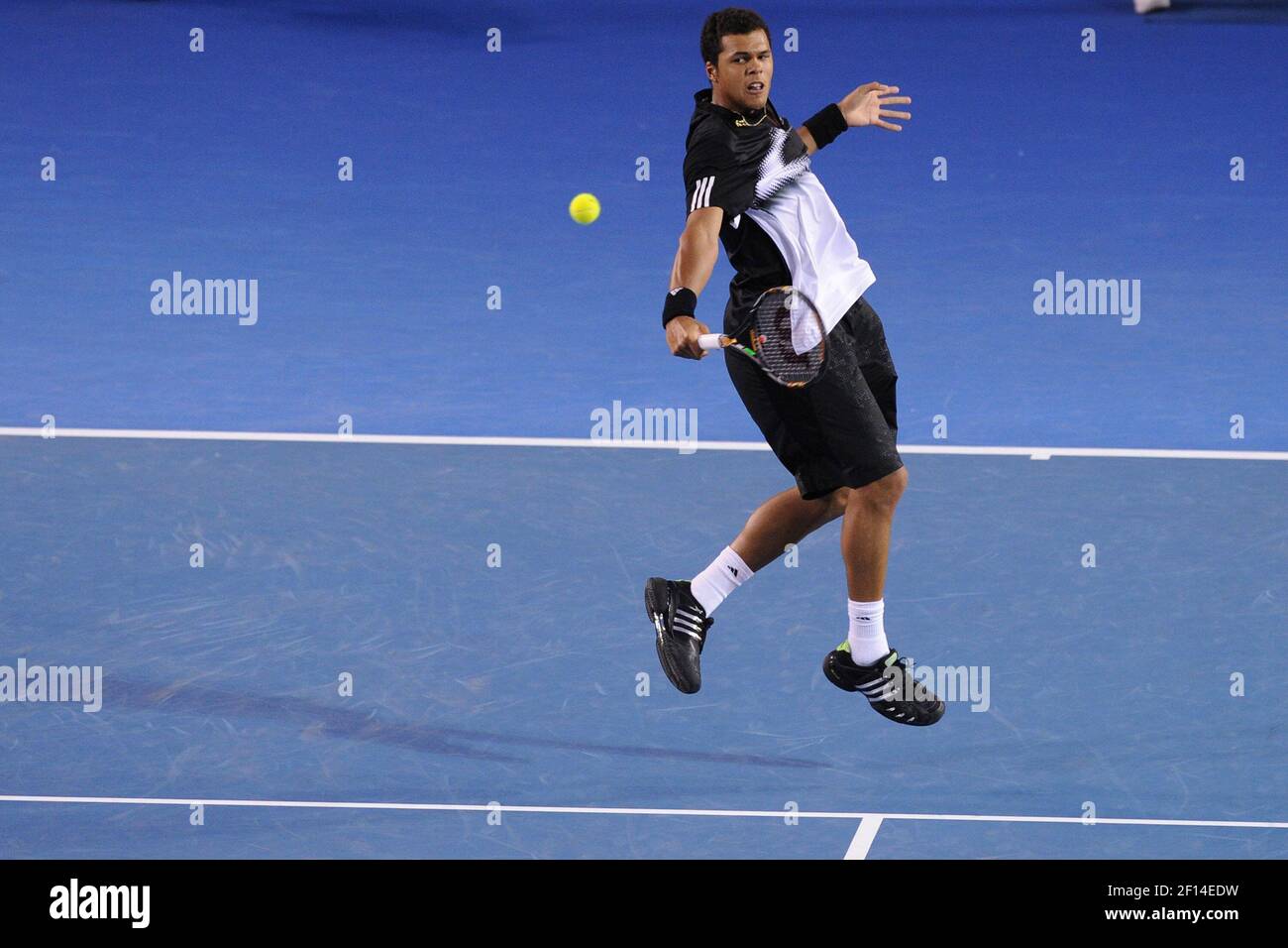 France's Jo-Wilfried Tsonga hits a return to Switzerland's Roger Federer  during their quarterfinal match at the Australian Open tennis championship  in Melbourne, Australia, Wednesday, Jan. 23, 2013.(AP Photo/Andrew  Brownbill Stock Photo -