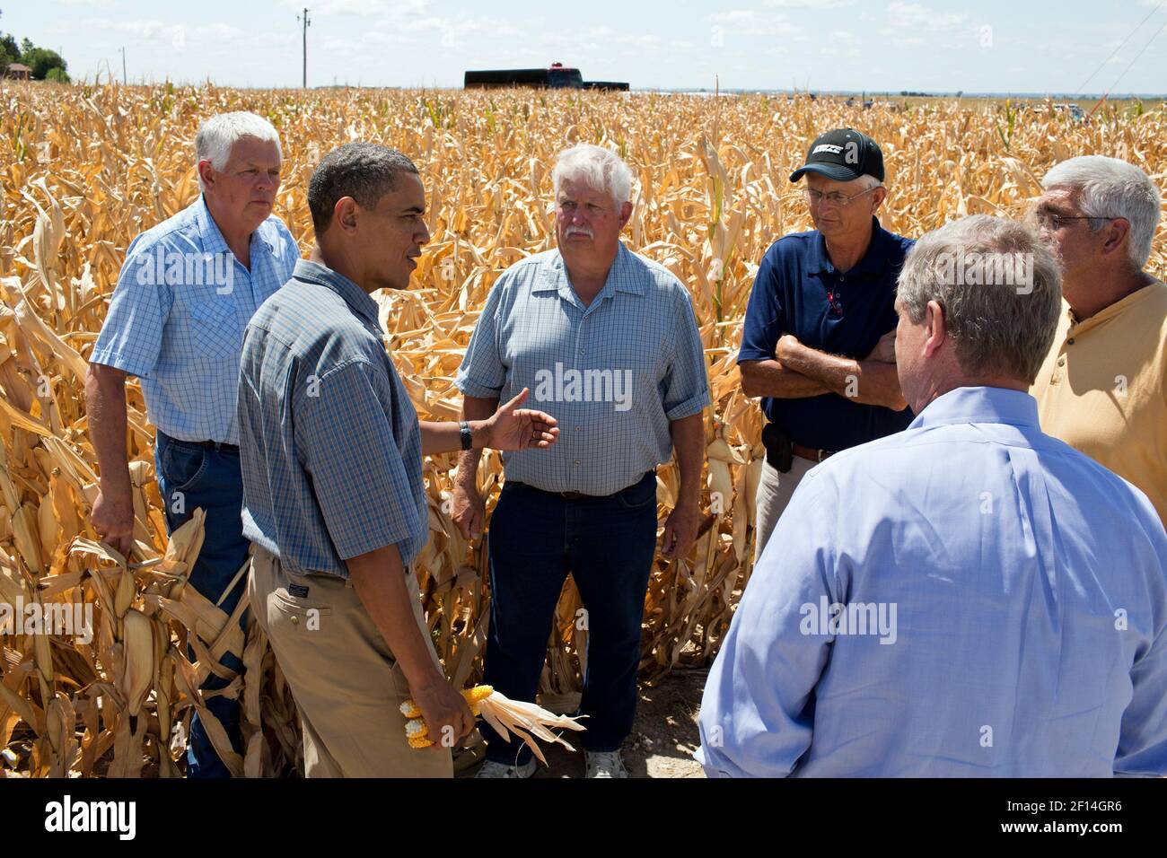 President Barack Obama talks with farmers during a tour of the McIntosh family farm to view the effects of the drought, in Missouri Valley, Iowa, Aug. 13, 2012. Secretary of Agriculture Tom Vilsack, foreground, joins the President Stock Photo