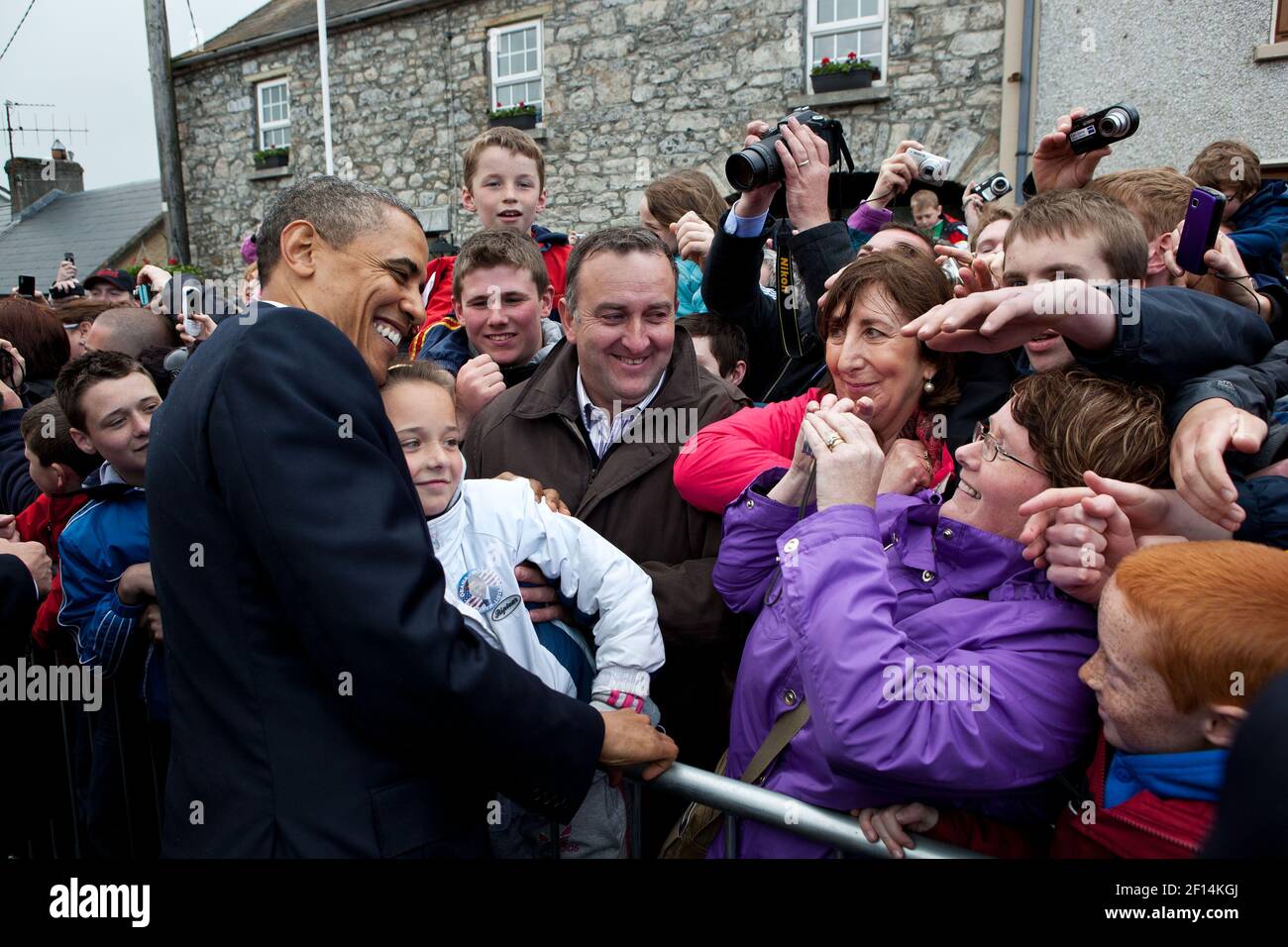 President Barack Obama is photographed with a young girl during a walk along Main Street in Moneygall Ireland May 23 2011. Stock Photo