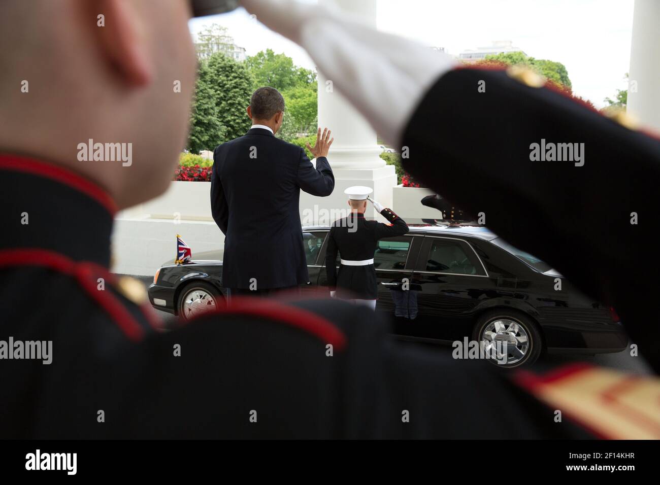 President Barack Obama waves to Prime Minister David Cameron of the United Kingdom as his car departs the North Portico of the White House, May 13, 2013 Stock Photo