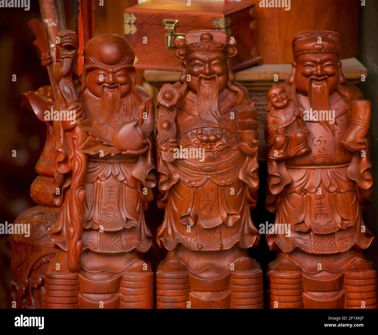 Confucian figurines for sale in a shop, Hanoi, Vietnam. Carved wood. Sanxing. Porcelain figurines of Fu Lu Shou. The Tao Gods of Good Fortune, Prosperity, and Longevity Stock Photo