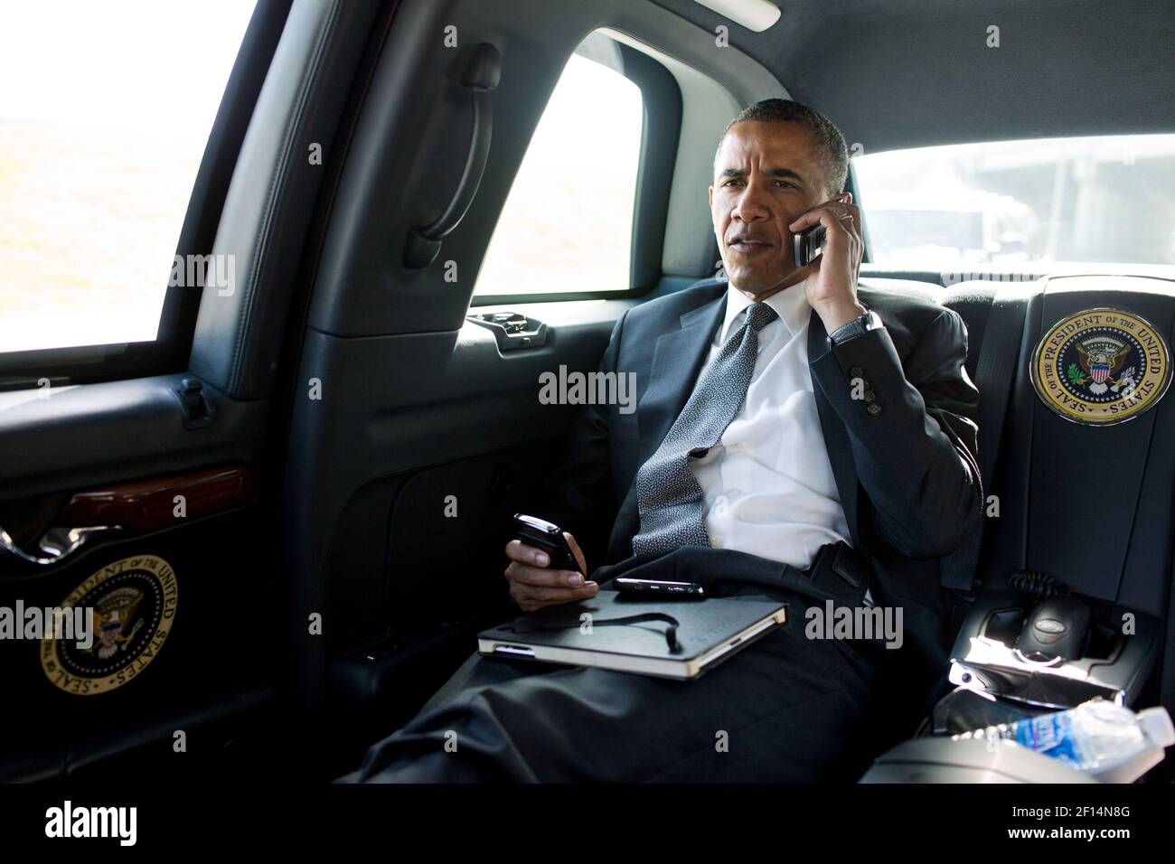 President Barack Obama talks on the phone with Aurora Mayor Steve Hogan during the motorcade ride to Palm Beach International Airport in Palm Beach Fla. July 20 2012. The President called Mayor Hogan to offer his condolences and support to the Aurora community. Stock Photo