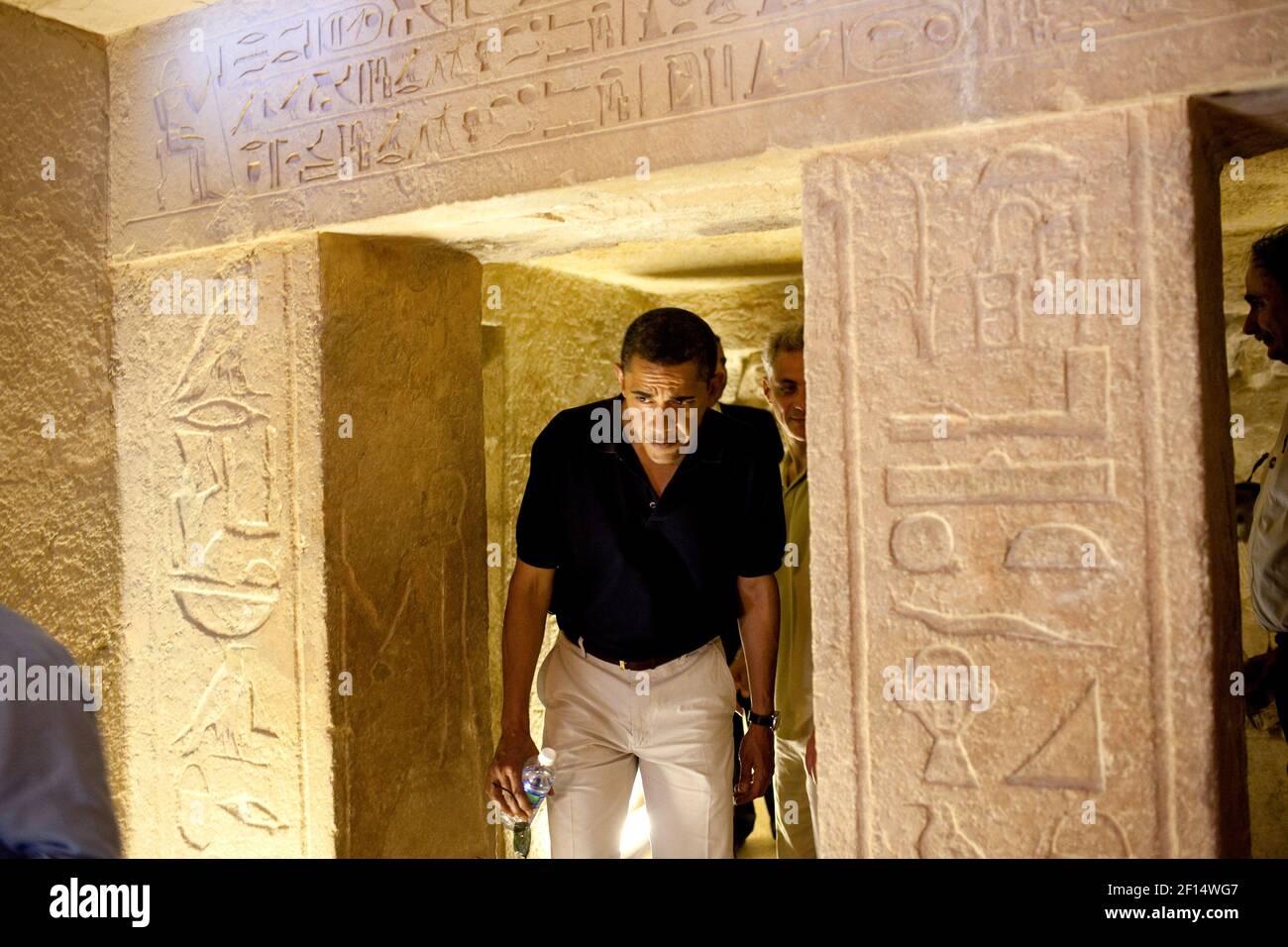 President Barack Obama ducks his head to get through an entranceway on a tour of the Pyramids and Sphinx in Egypt June 4 2009. Stock Photo