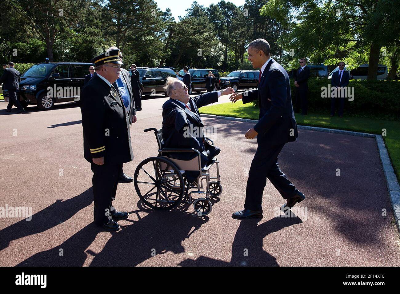 President Barack Obama is welcomed by former Senator Max Cleland and Dan Neese, upon arrival for the 70th French-American Commemoration D-Day Ceremony in Colleville-sur-Mer, France, June 6, 2014 Stock Photo