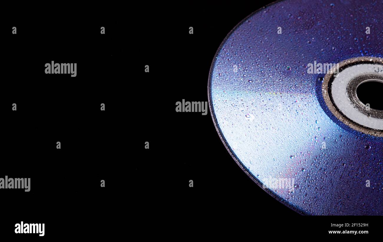 cd disk in the rain. cd drive trash. cd disc. compact disc isolated on black background. Stock Photo