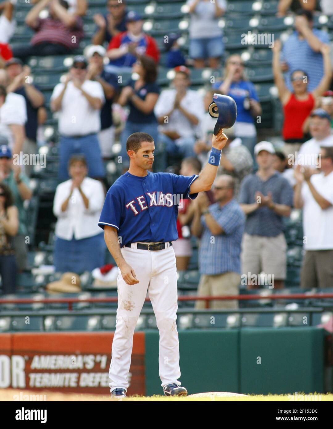 Texas Rangers' Michael Young tips his batting cap to the cheers of