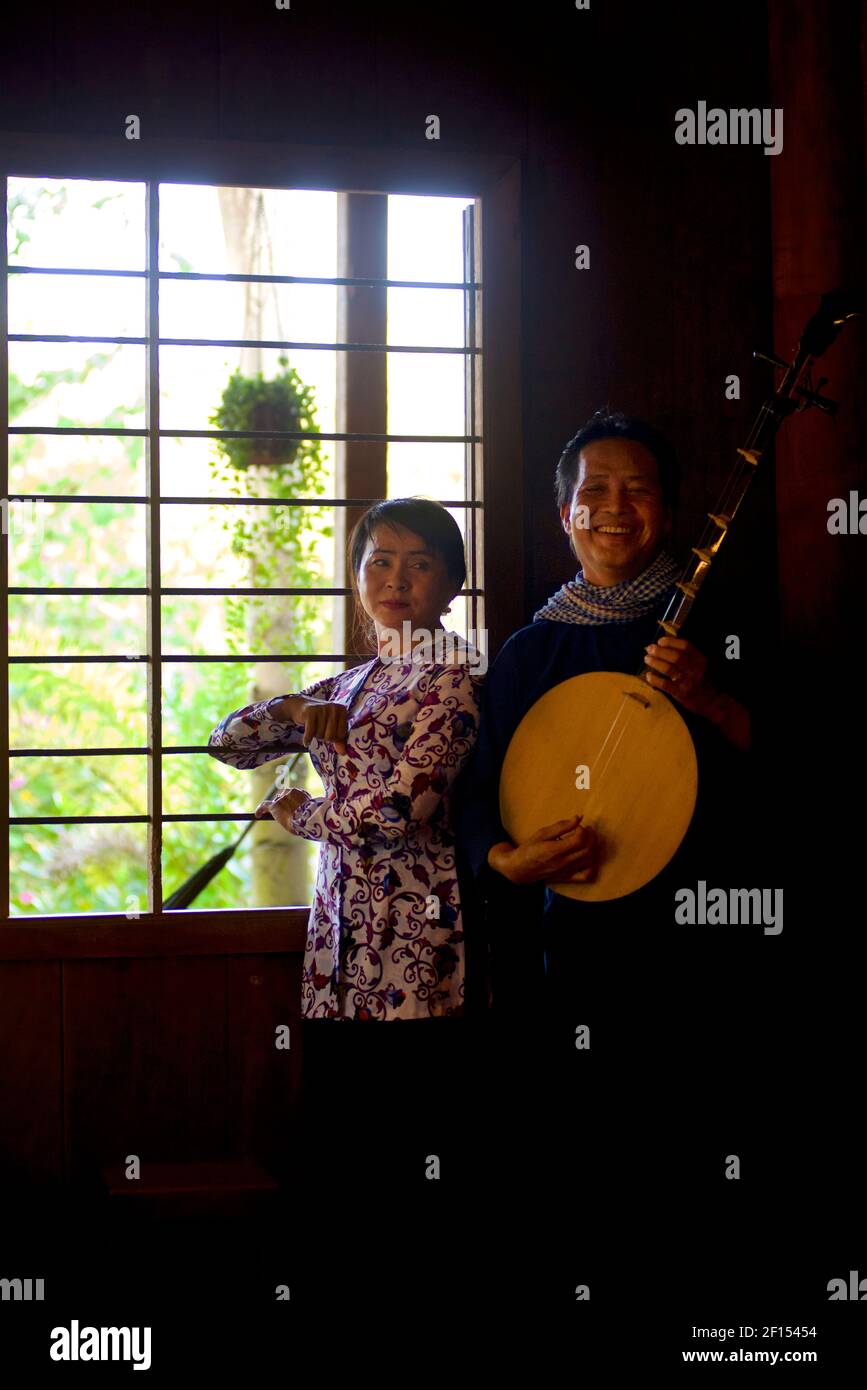 Vietnamese musician playing a moon lute, and woman dancing, Can Tho, Mekong Delta, Southern Vietnam Stock Photo
