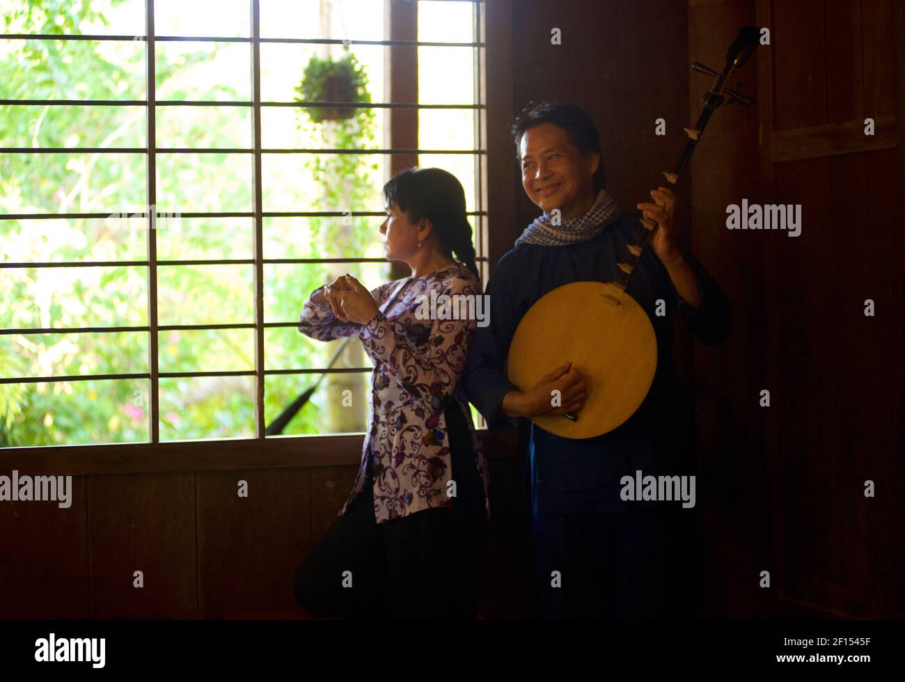 Vietnamese musician playing a moon lute, and woman dancing, Can Tho, Mekong Delta, Southern Vietnam Stock Photo