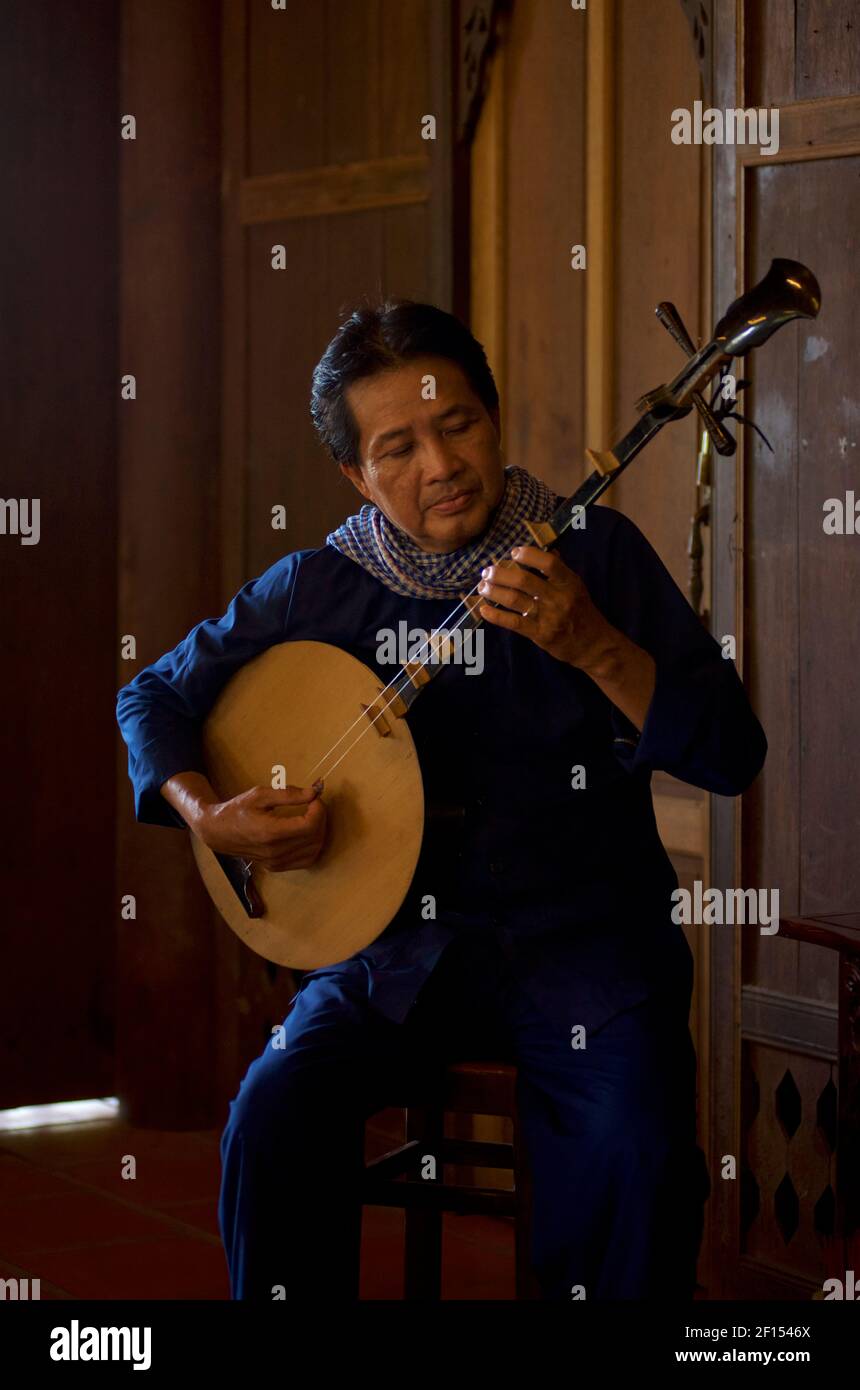 Vietnamese musicians playing a moon lute, Can Tho, Mekong Delta, Southern Vietnam. The đàn nguyệt also called nguyệt cầm, đàn kìm, is a two-stringed Vietnamese traditional musical instrument. Stock Photo
