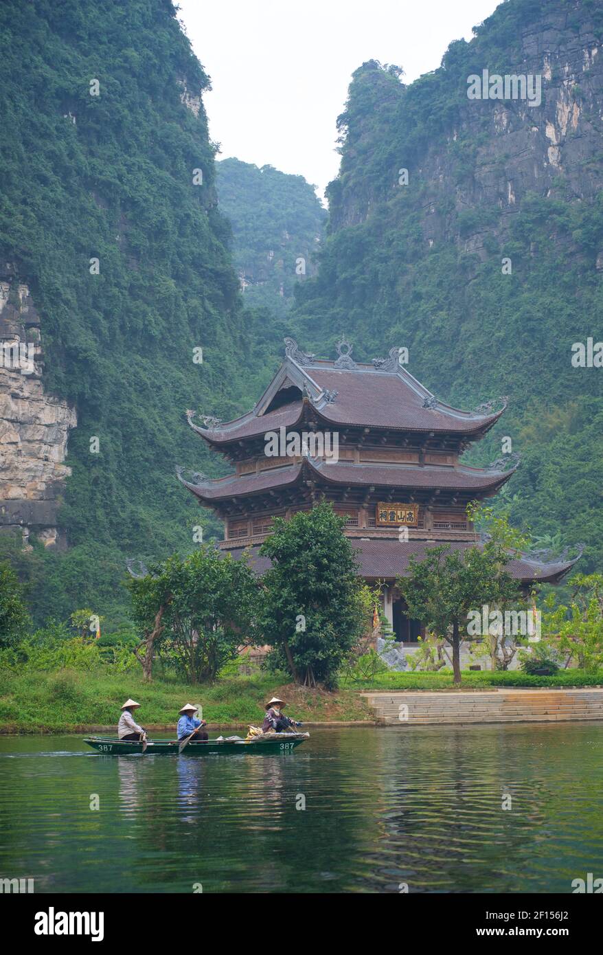 Travellng by river boat around the Trang An Scenic Landscape Complex, Ninh Binh, Vietnam. Pagoda Stock Photo