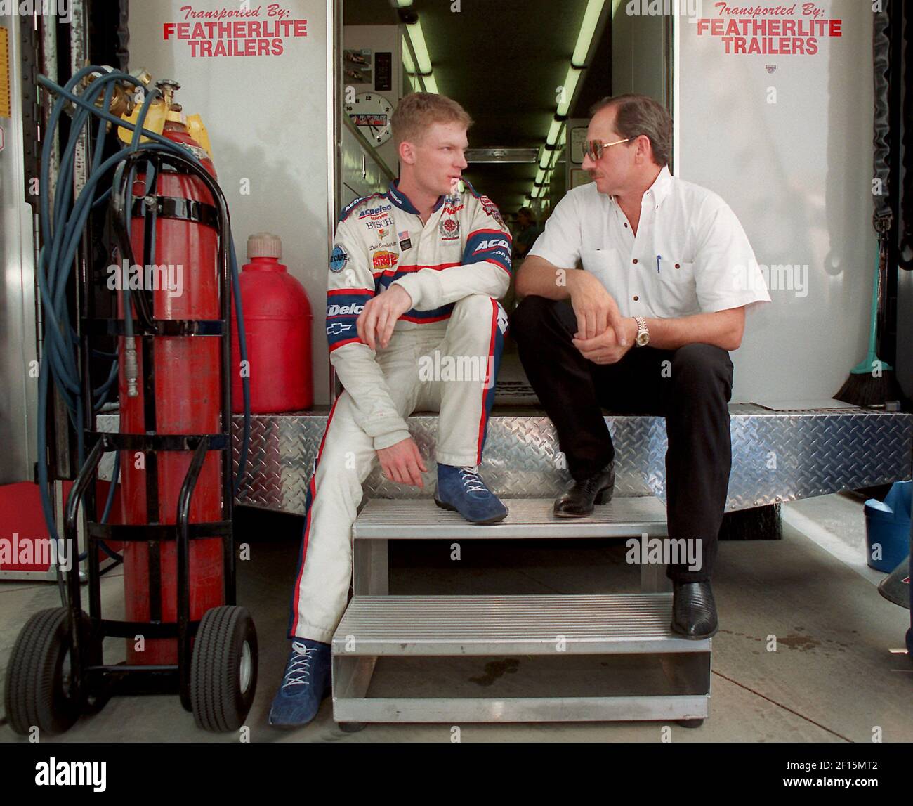 Dale Earnhardt Jr. and Dale Earnhardt Sr., sit on the back of a