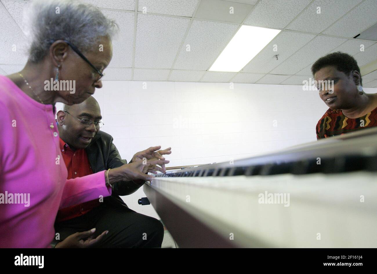 Zeophis Campbell, left, and Pat Collins, right, get a piano lesson from John Hopkins, at the Swope Ridge Geriatrics Center in Kansas City, Kansas, March 27, 2007. Hopkins retaught himself how to play the piano with just his left hand after he suffered a stroke. (Photo by Jim Barcus/Kansas City Star/MCT/Sipa USA) Stock Photo