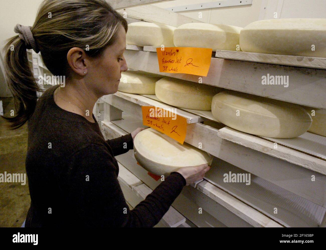 Sales representative and bookkeeper Rhonda Silveira places a wheel of