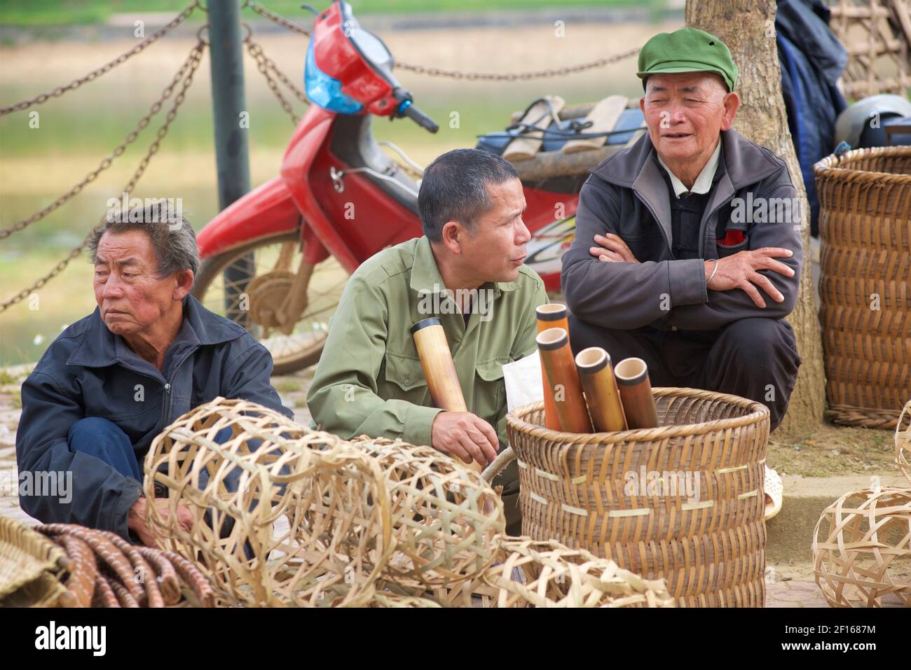Vietnamese men selling baskets and bongs made of bamboo at Bac Ha market. Lao Cai province, Vietnam Stock Photo