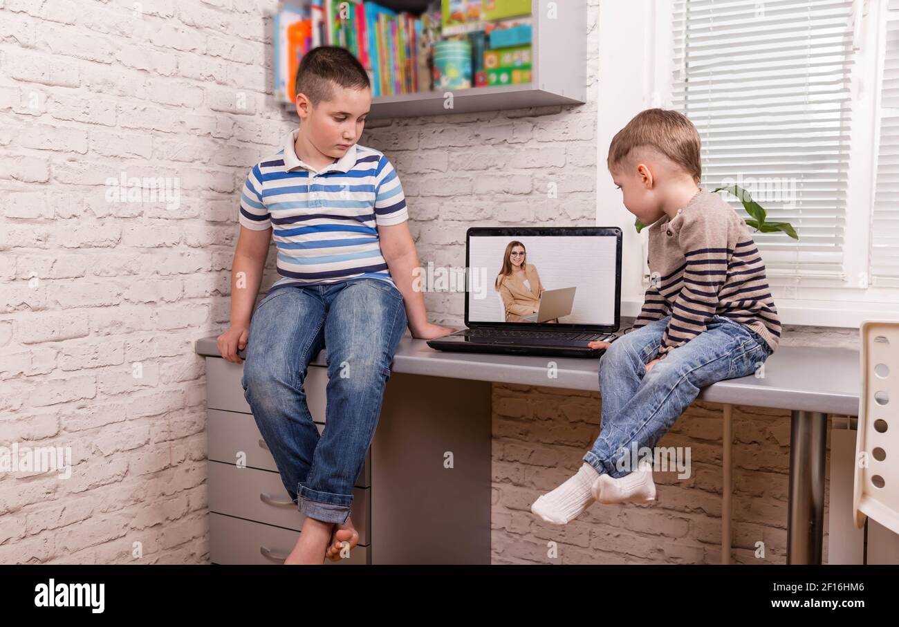 Two happy small friends. Boys using smart digital tablet at home. Stock Photo