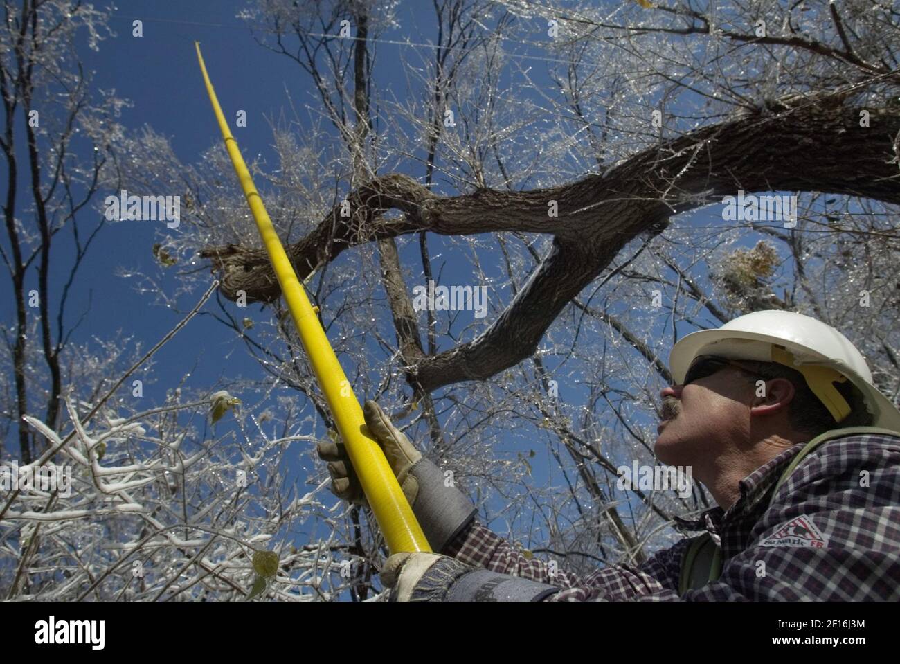 ameren-ue-apprentice-lineman-ken-moonier-raises-a-pole-with-a-saw-on-the-end-to-clear-branches-in-danger-of-breaking-power-lines-in-black-jack-missouri-saturday-december-2-2006