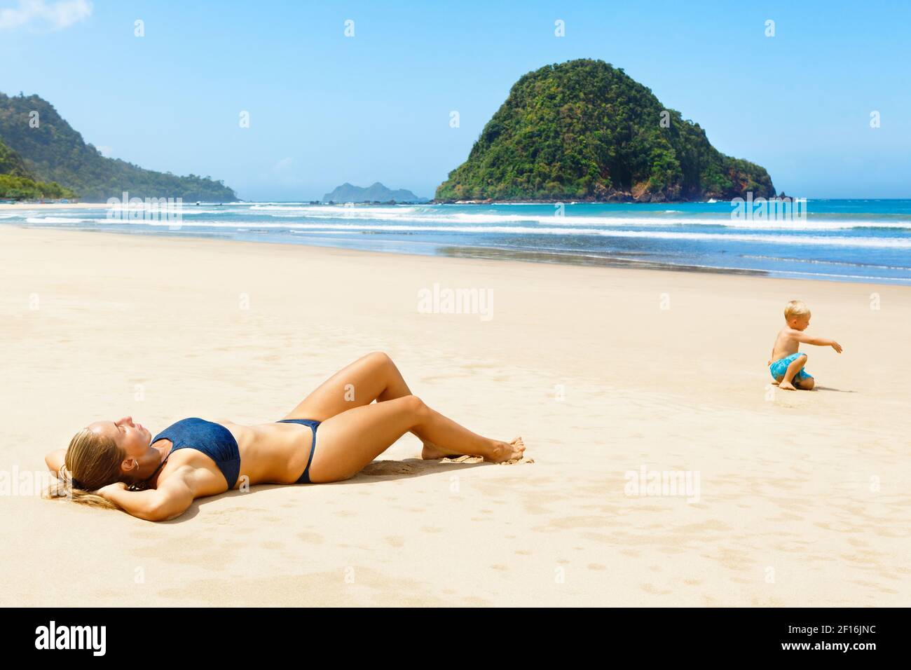 Happy young woman relax on tropical sand beach. Red island beach, pantai  Pulau merah, Banyuwangi, east Java, Indonesia. Popular travel destination  Stock Photo - Alamy