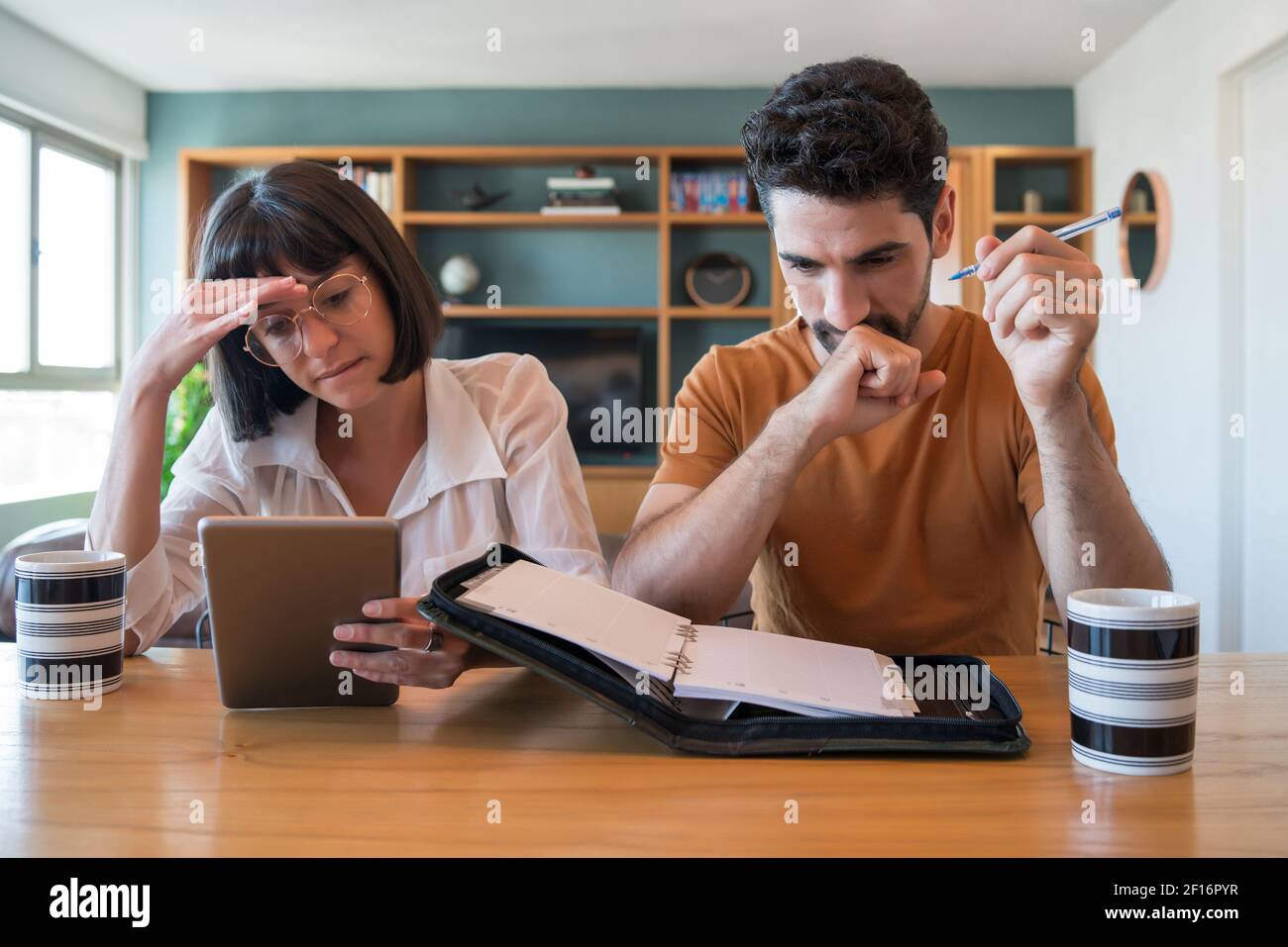 Young couple paying bills on digital tablet. Stock Photo