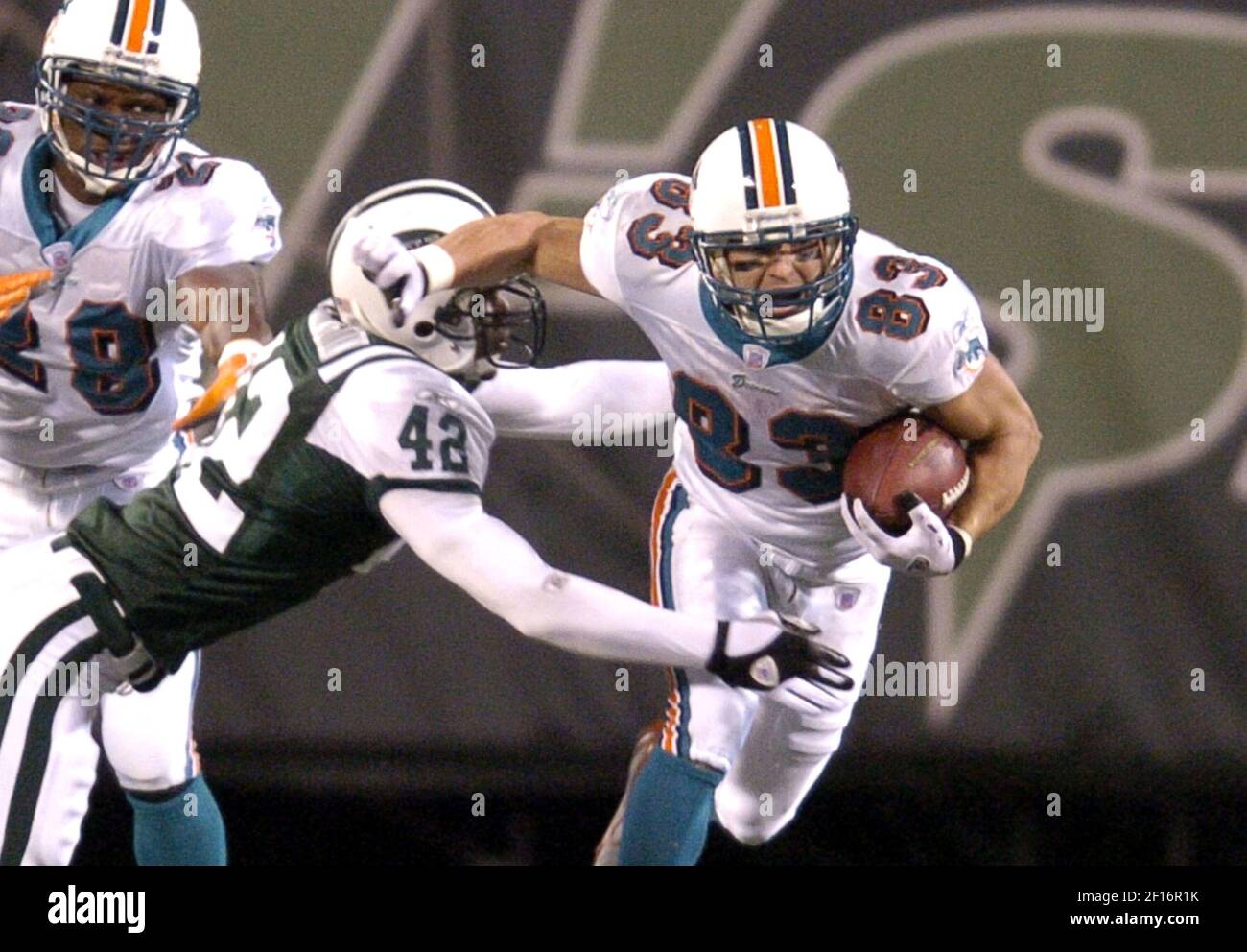 Miami Dolphins wide receiver Wes Welker (83) of the Dolphins tries to slip  the grasp of the New York Jets' Rashad Washington in the fourth quarter.  The Jets defeated the Dolphins, 20-17,