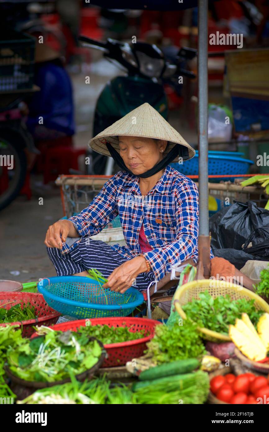 Vietnamese vegetables vendor in distinctive conical hat. Hoi An market, Vietnam Stock Photo