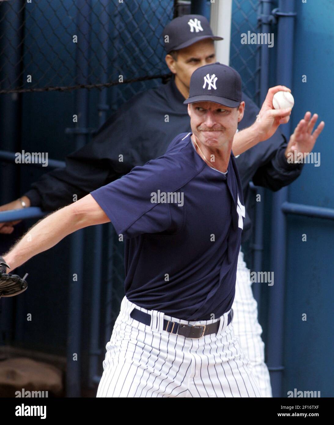 New York Yankees pitcher Randy Johnson throws in the bullpen as Yankees  manager Joe Torre watches during their game against the Toronto Blue Jays  at Yankee Stadium in Bronx, New York, Sunday