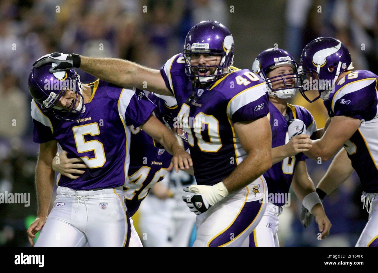 Minnesota Vikings' Jim Kleinsasser (40) gives a friendly slap to the helmet  to Vikings punter/holder Chris Kluwe after Ryan Longwell (right) kicked the  game winning field goal in overtime at the Metrodome