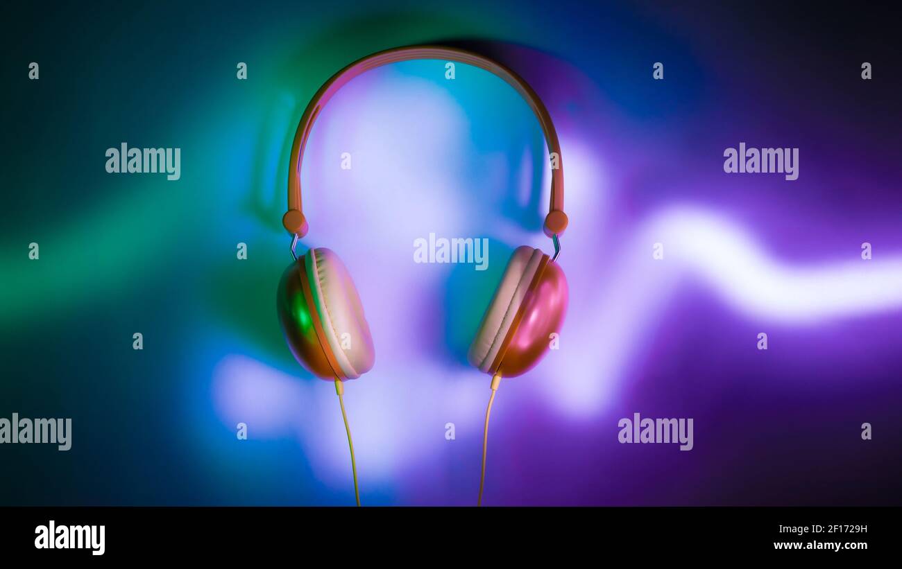 Headphones in dark with neon light audio graph Stock Photo