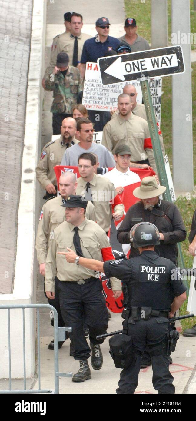 A police officer directs Neo-Nazis marching in downtown Orlando ...