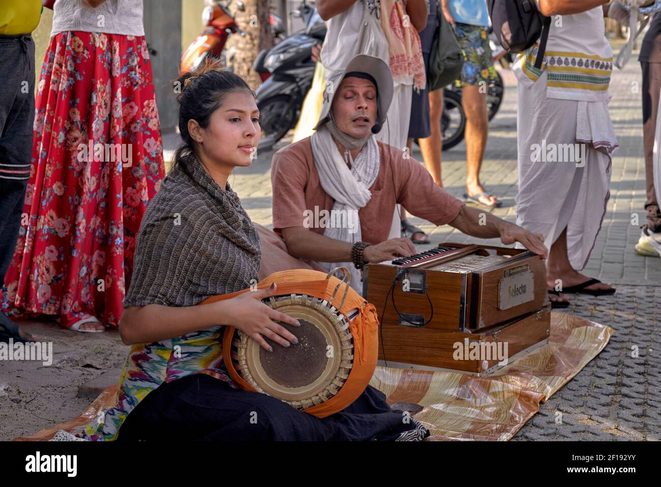 Hare Krishna musicians playing harmonium and drum on the street in
