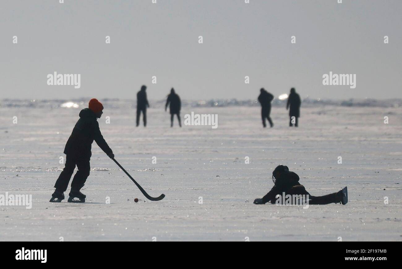 Children play hockey on the frozen Lake Baikal in the village of Bolshoye Goloustnoye in Irkutsk region, Russia March 8, 2021. REUTERS/Maxim Shemetov Stock Photo