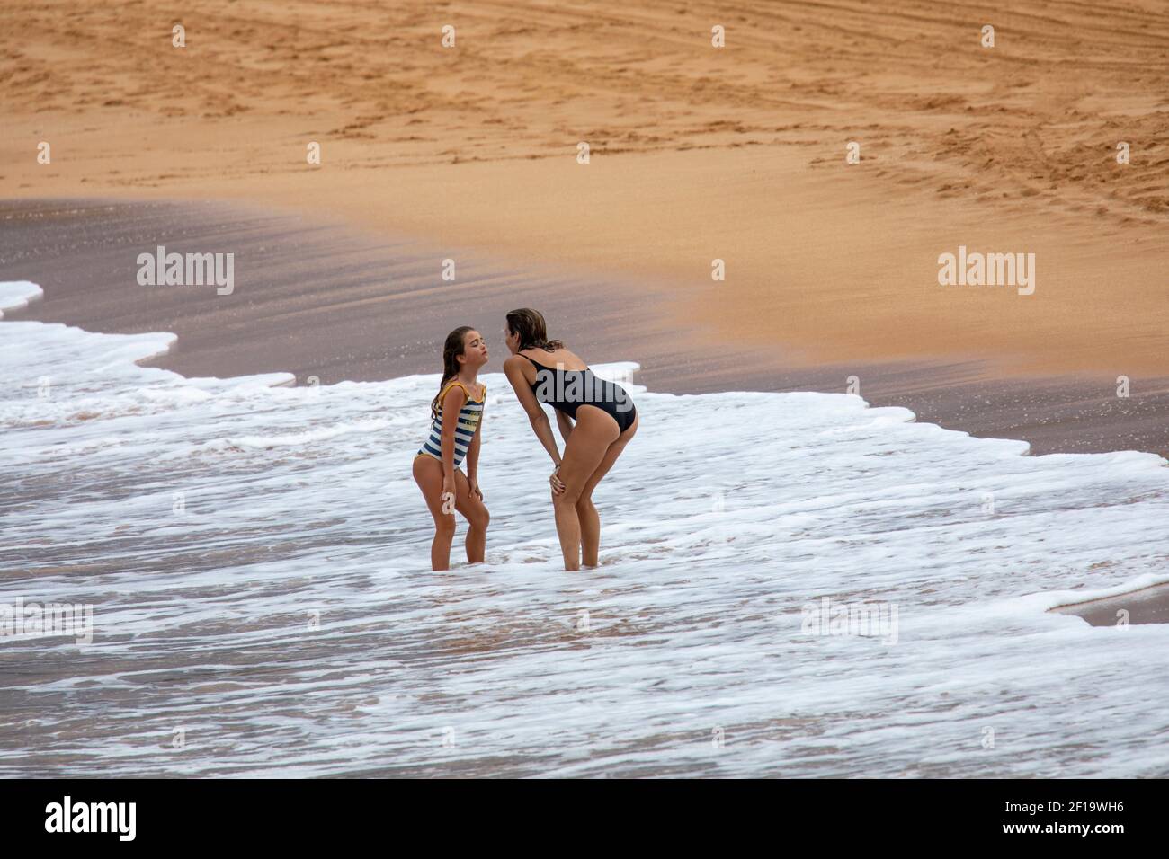 Mother and daughter spend quality time together having fun on a Sydney beach in Australia Stock Photo