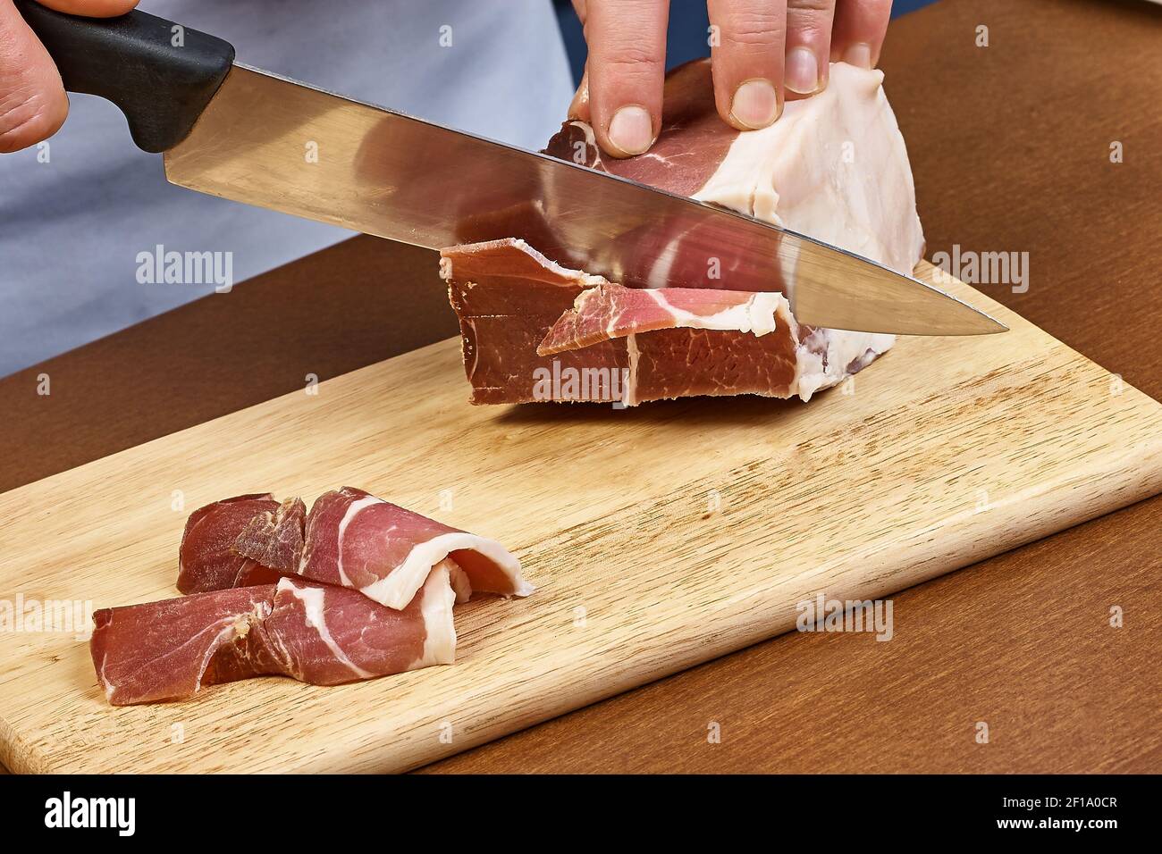 Dry cured ham thinly sliced Closeup on chef hands slices prosciutto