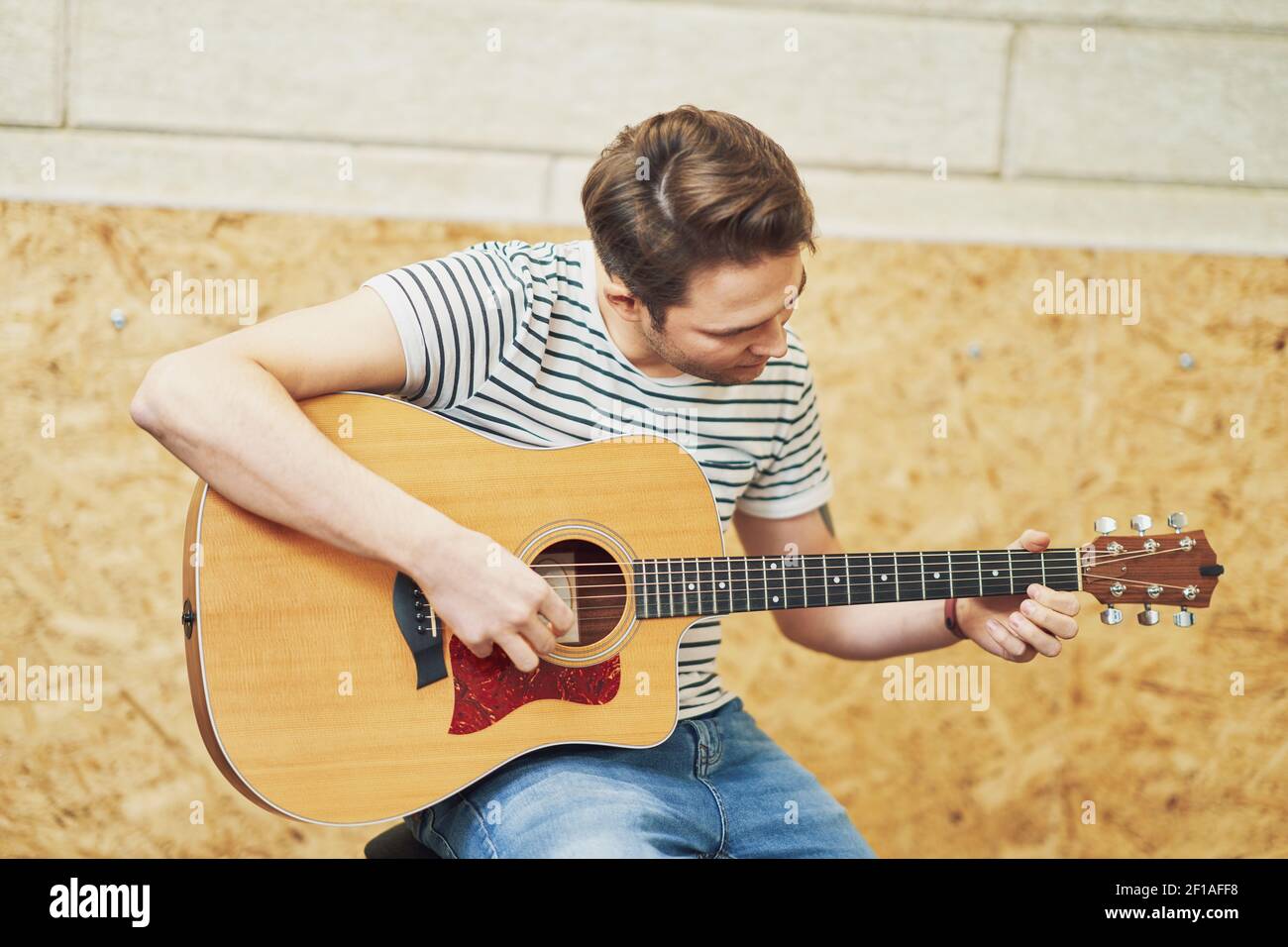 Handsome man playing guitar in studio Stock Photo