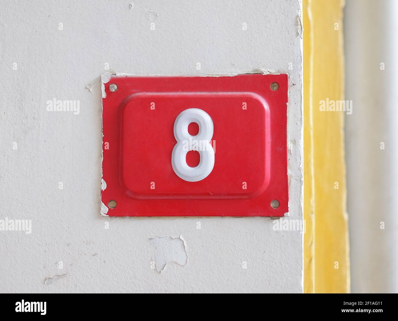 Red house street number 8 on the wall Stock Photo