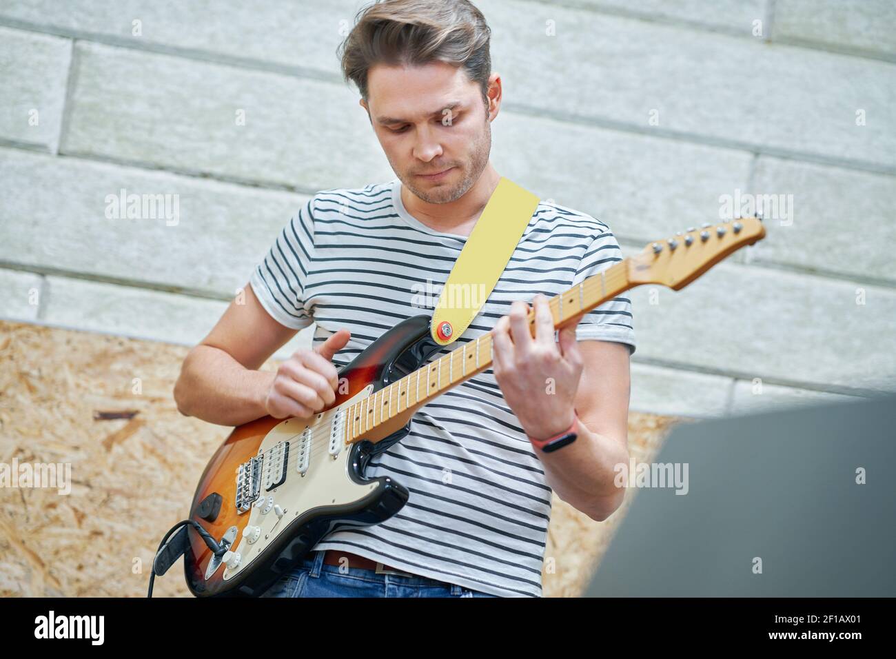 Handsome man playing guitar in studio Stock Photo