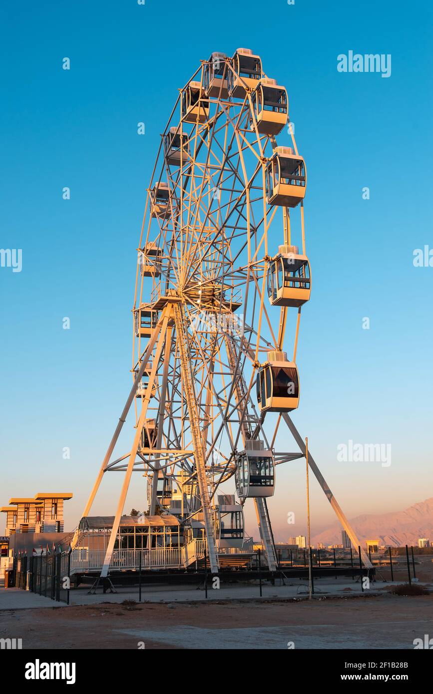 Ras al Khaimah, United Arab Emirates - January 13, 2021: Large Ferris wheel in Ras Al Khaimah corniche area at sunset in the heart of northern emirate Stock Photo