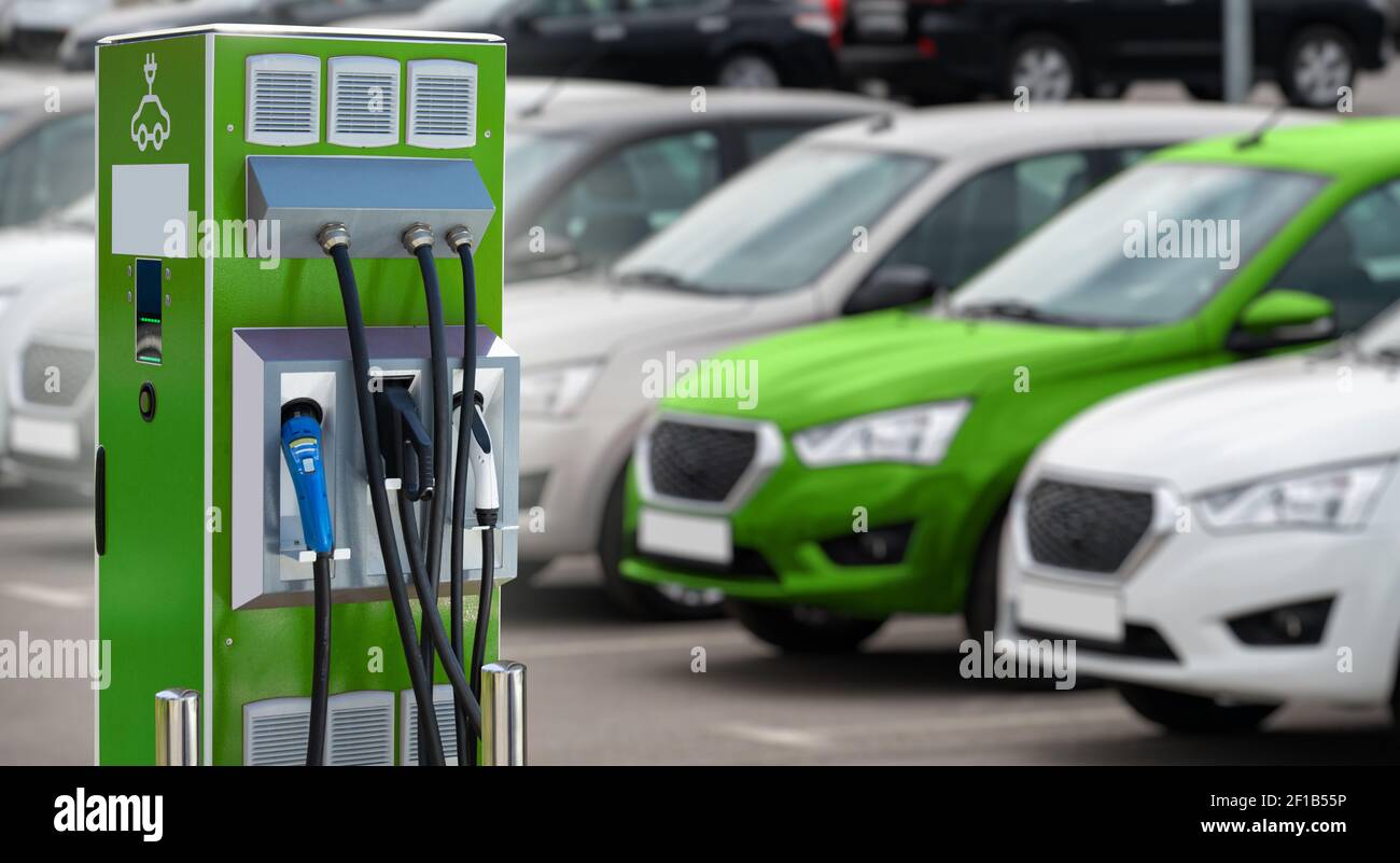 Electric vehicles charging station on a background of a row of cars. Concept  Stock Photo