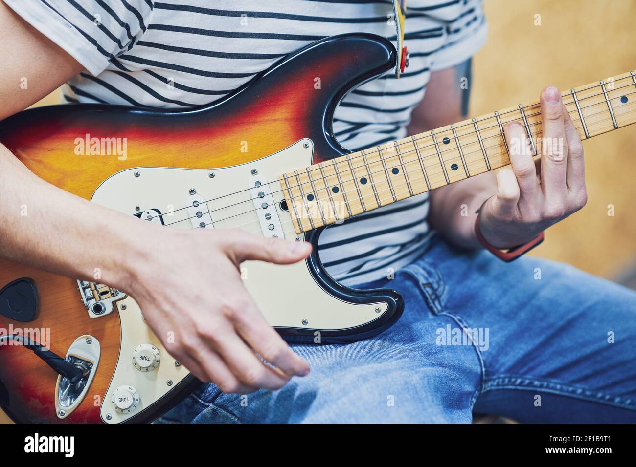 Handsome man playing guitar in studio Stock Photo